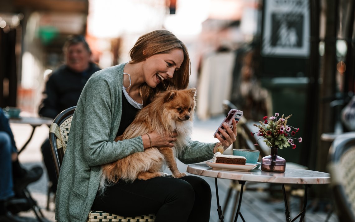 Mobiltelefon og jente på kafe