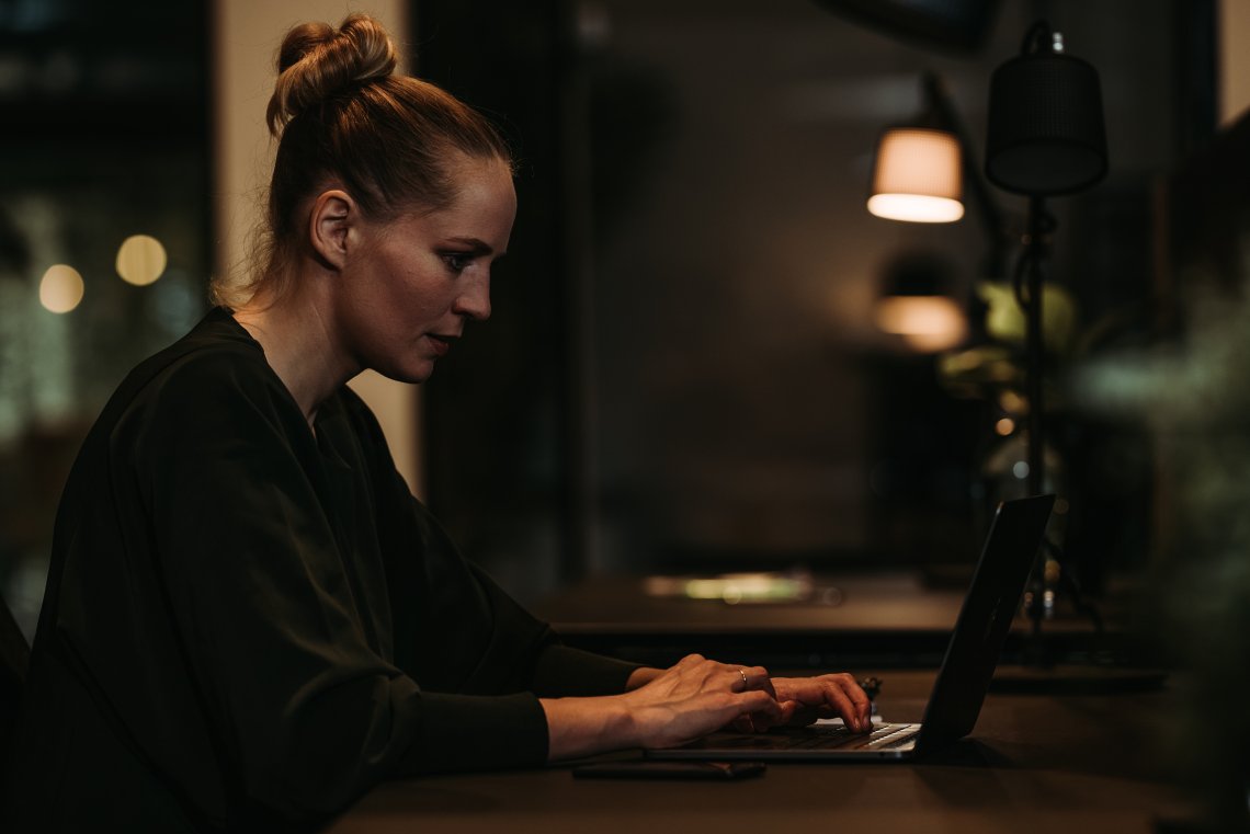 Kvinne ved laptop på bord