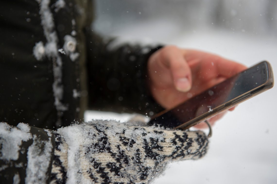 Person med mobil i snøvær