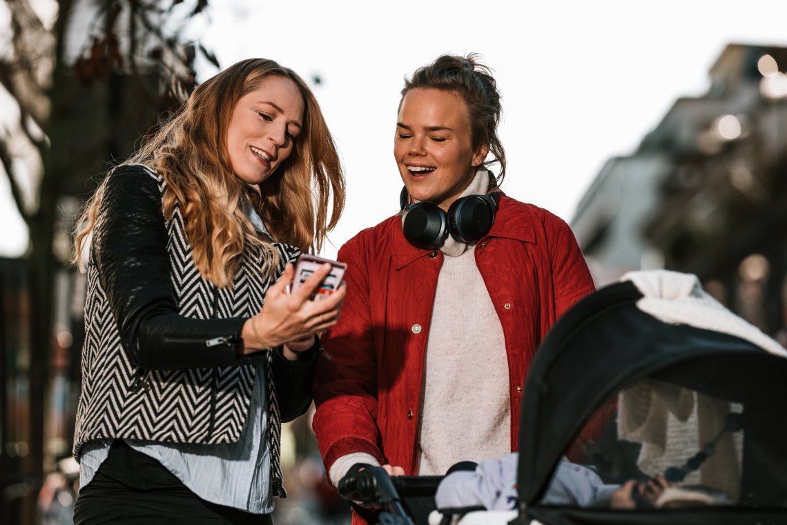 To kvinner ser på mobiltelefon